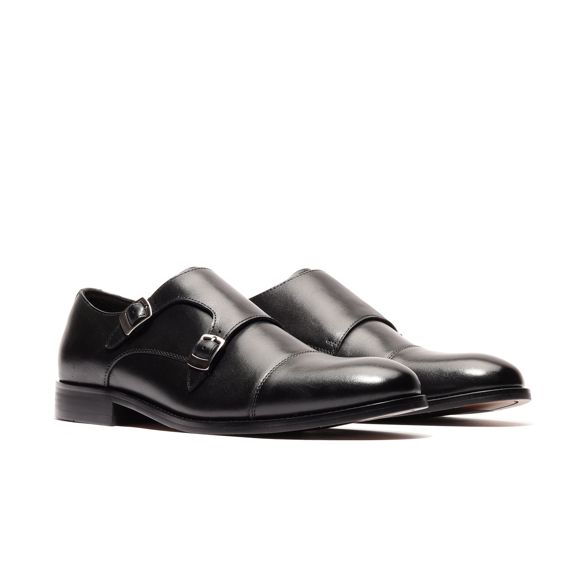 Angled view of two black genuine leather shoes, highlighting their sleek design and high-quality craftsmanship, perfect for formal and sophisticated occasions.